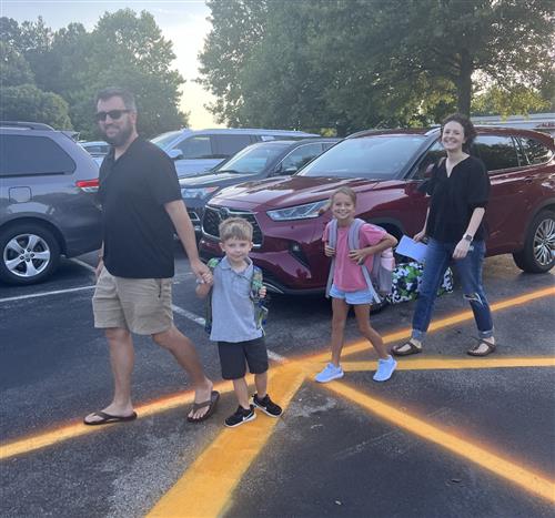 family walking across parking lot to Rainbow Elementary